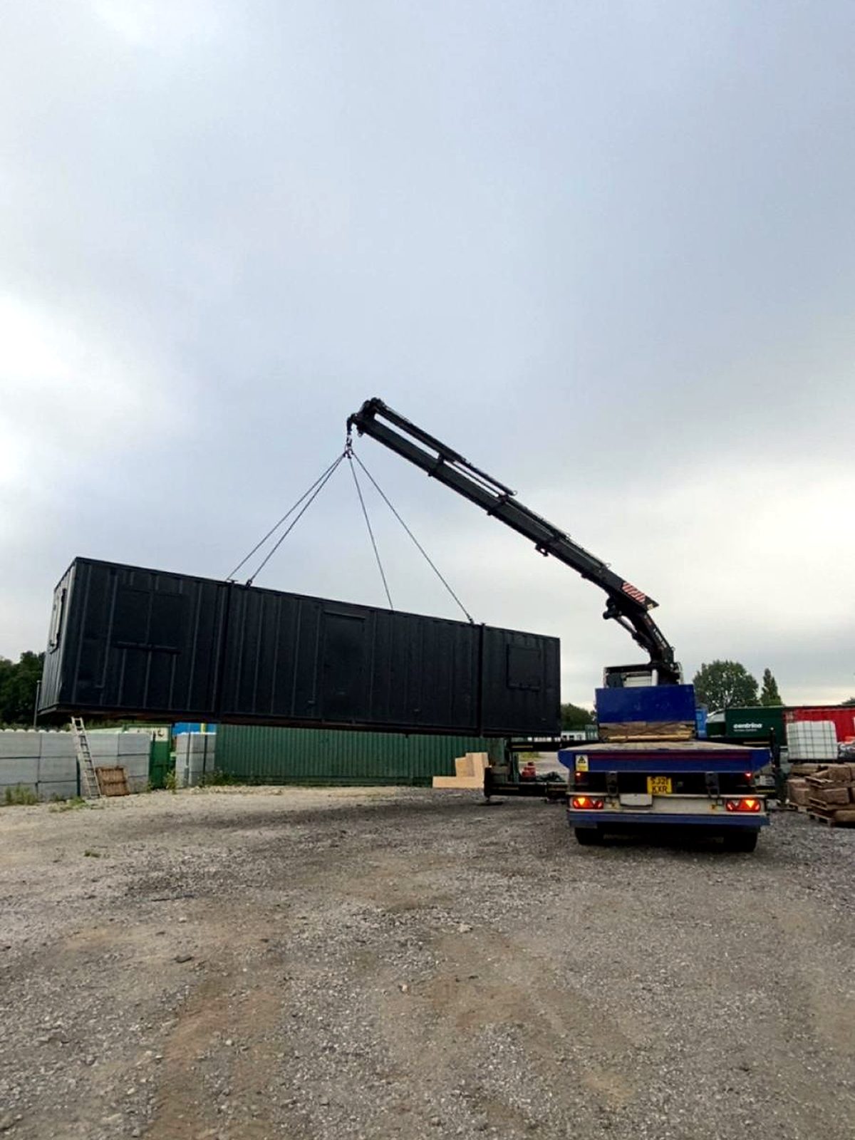 AC Lifting HIAB lifting a container off the yard for transport.