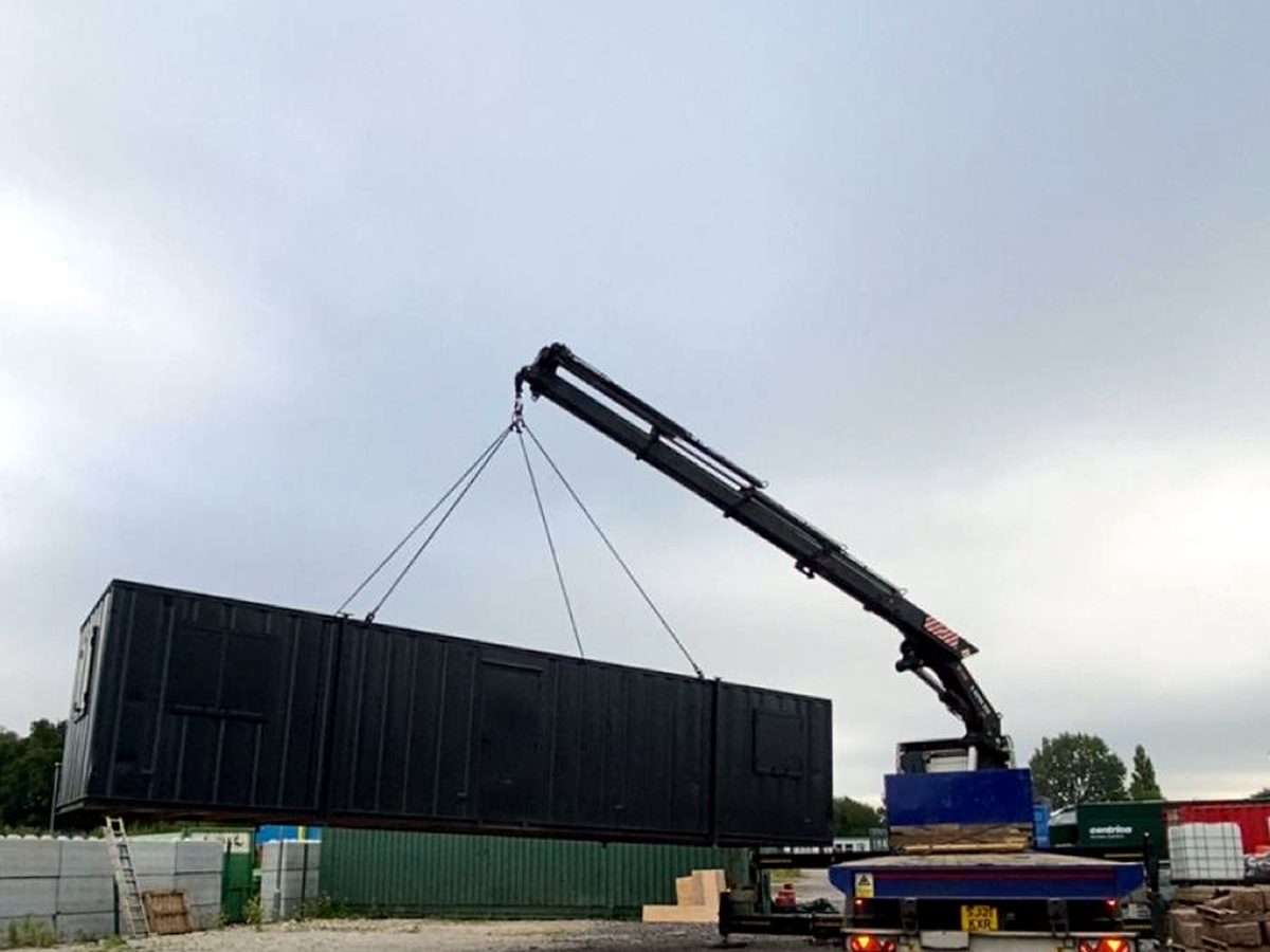 AC Lifting HIAB lifting a container off the yard for transport.
