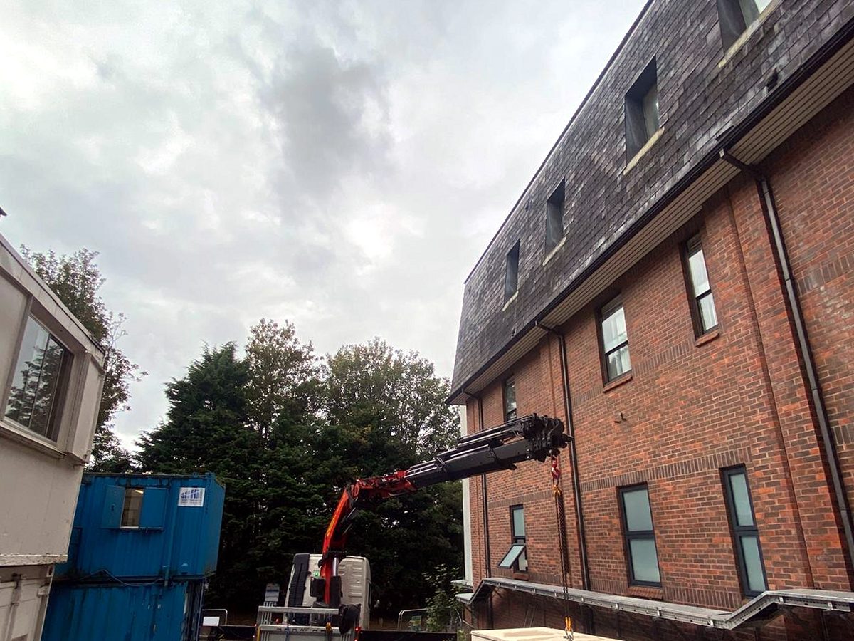 AC Lifting craning a GRP kiosk into precise position alongside a building.