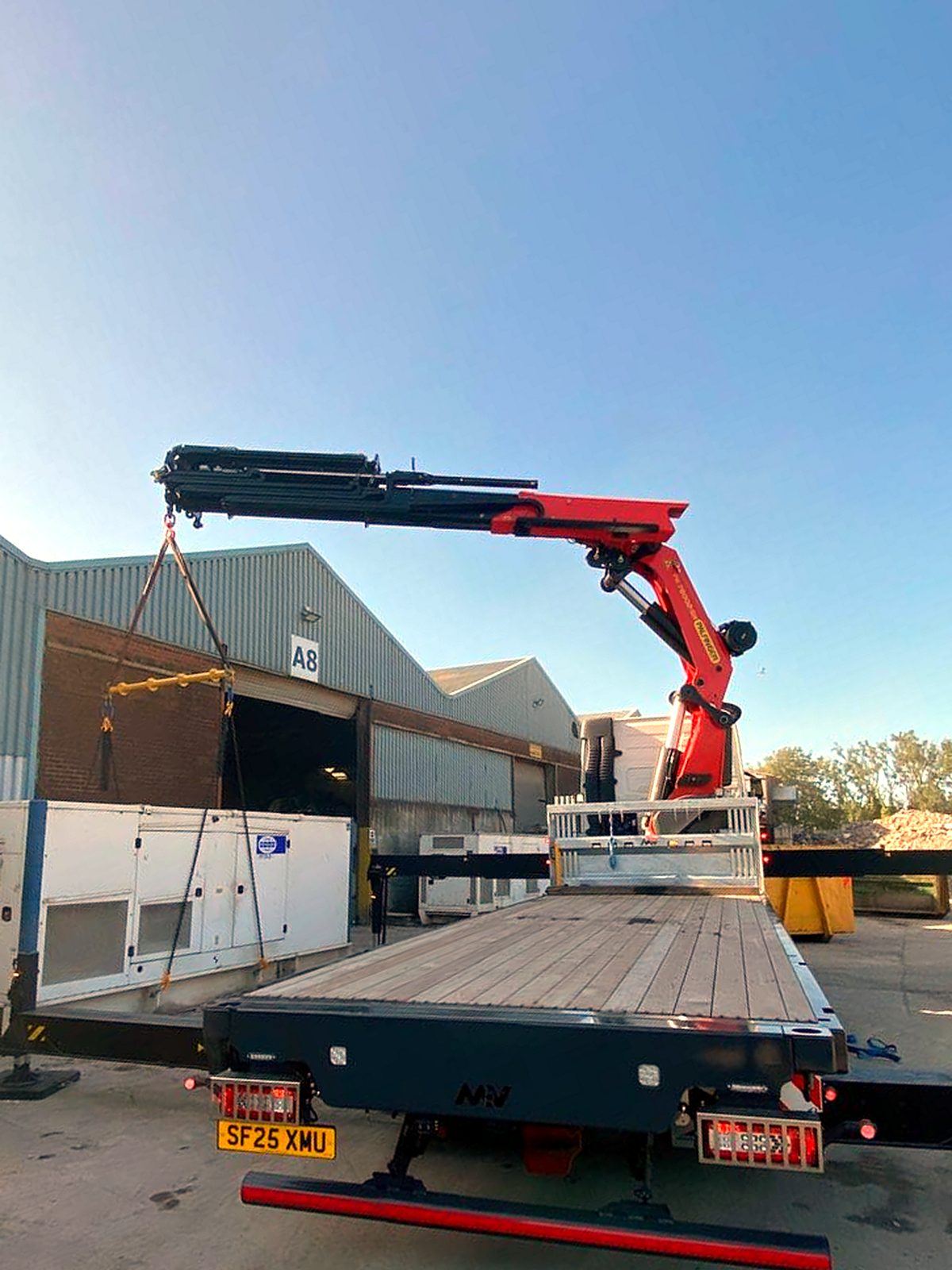 AC Lifting HIAB carrying out a lift at a warehouse loading door.