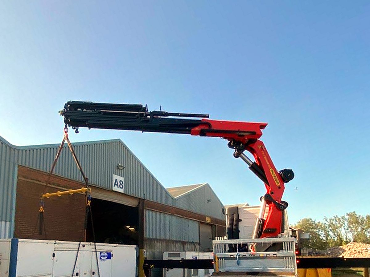 AC Lifting HIAB carrying out a lift at a warehouse loading door.