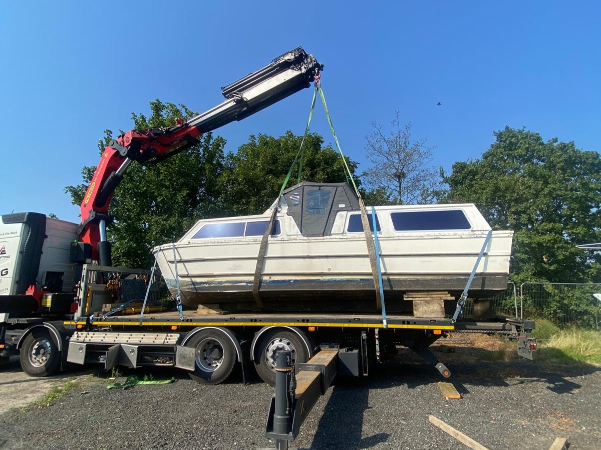 AC Lifting HIAB lowering a cabin cruiser onto a trailer.