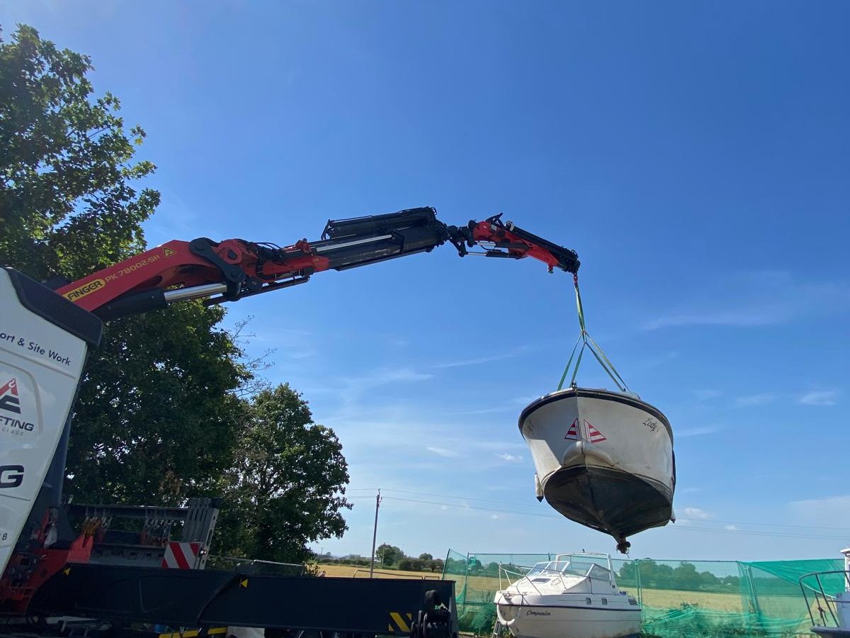 Small boat suspended from an AC Lifting HIAB crane during a lift.