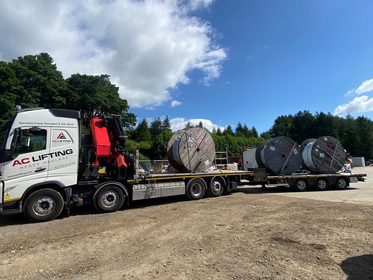 AC Lifting lorry and drawbar trailer delivering electricity cable drums to site.