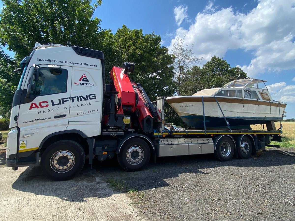 Classic cabin cruiser secured on an AC Lifting HIAB flatbed.