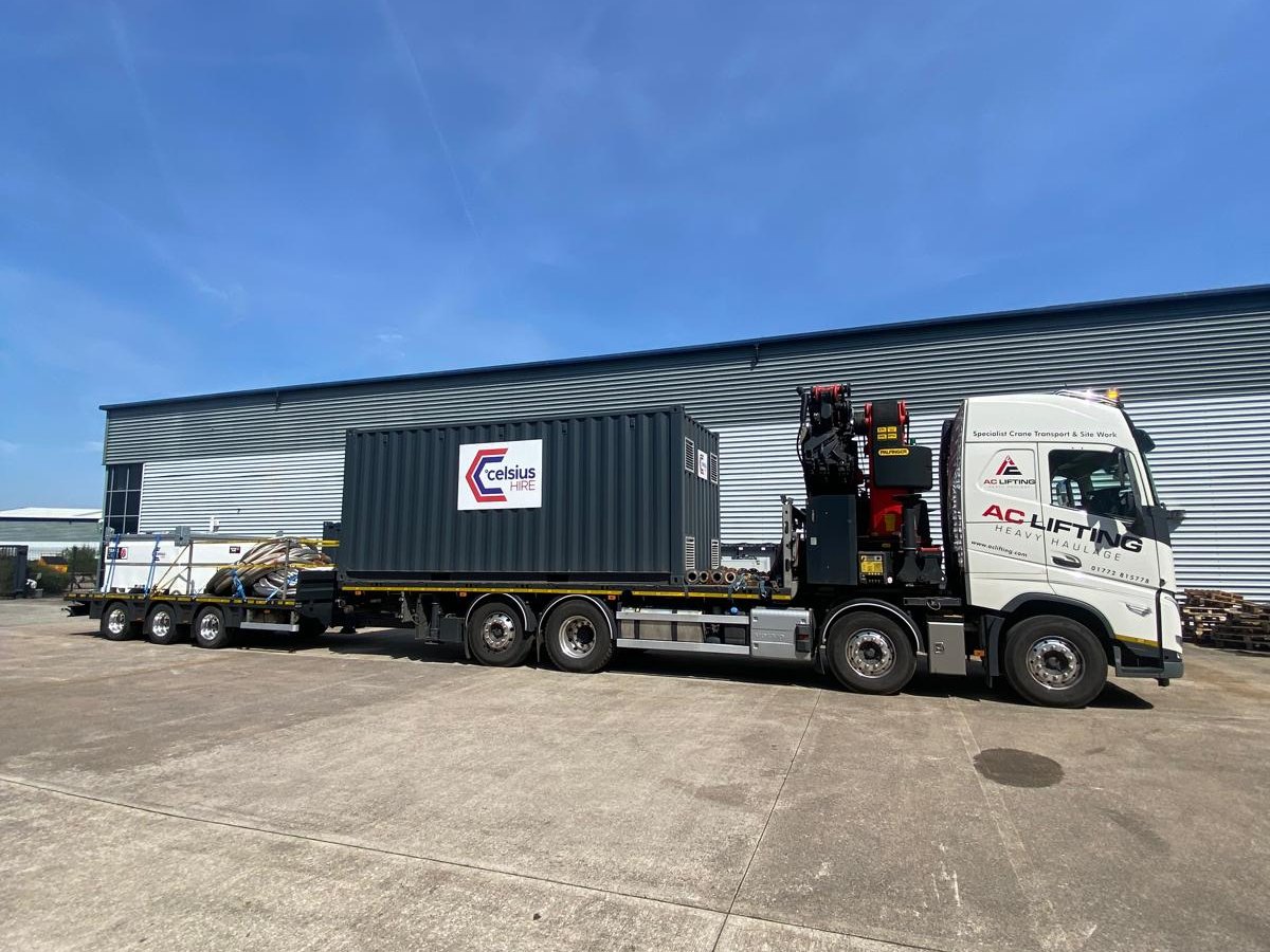 AC Lifting lorry and trailer loaded with a container at an industrial collection point.