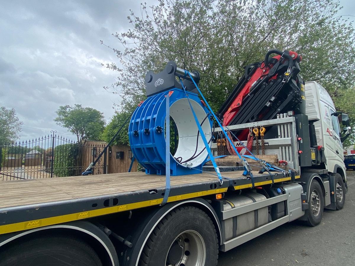 Blue GRP kiosk strapped and secured on an AC Lifting flatbed ready for transport.