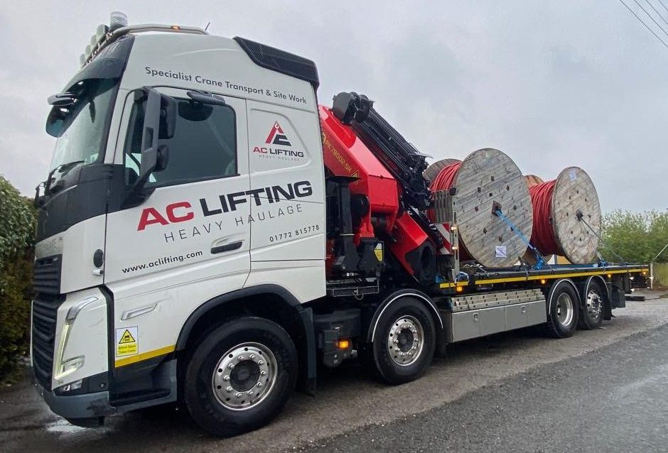 AC Lifting HIAB lorry loaded with electricity cable drums on a rural delivery run.