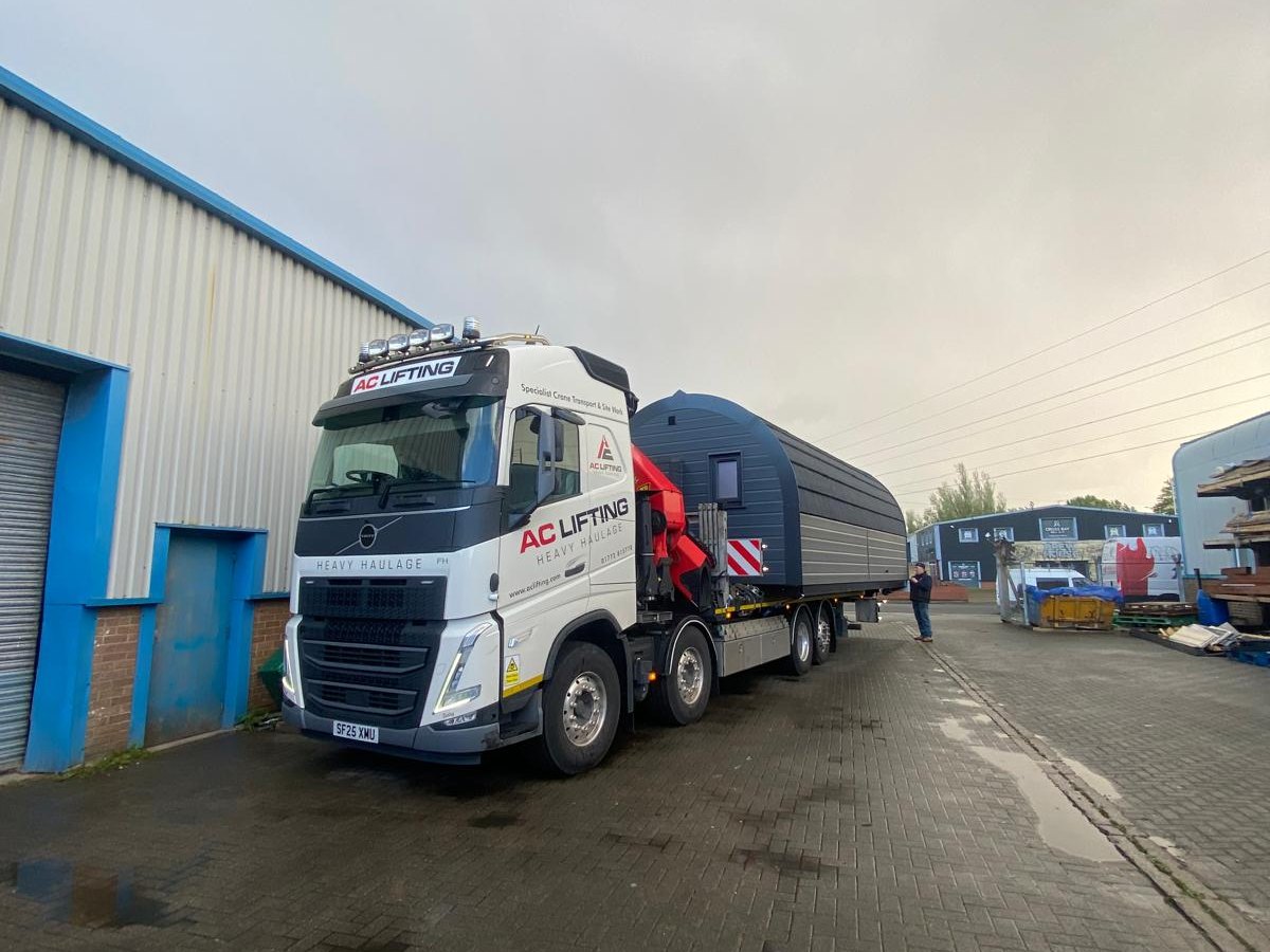 AC Lifting HIAB and trailer collecting a container from an industrial unit.