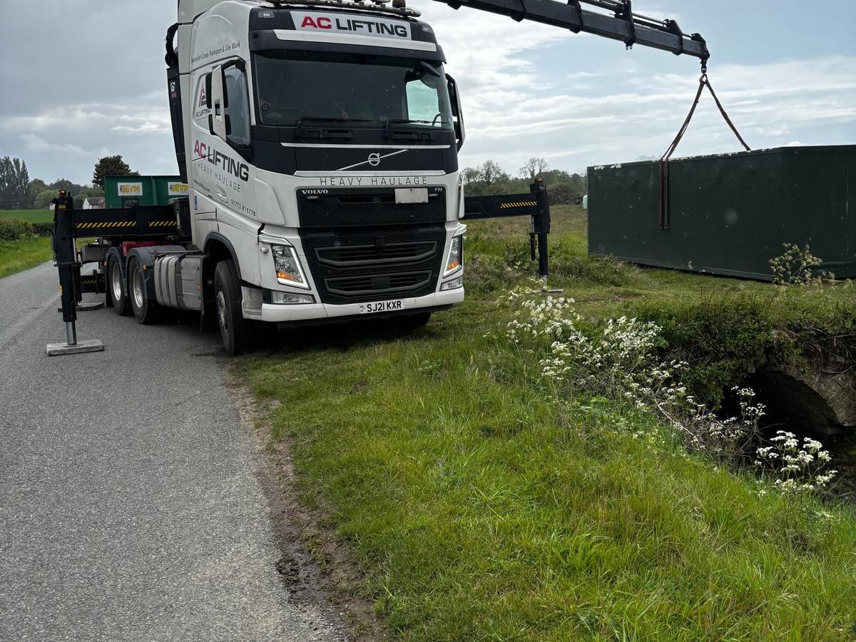 AC Lifting HIAB reaching over a hedge and ditch to complete a lift.