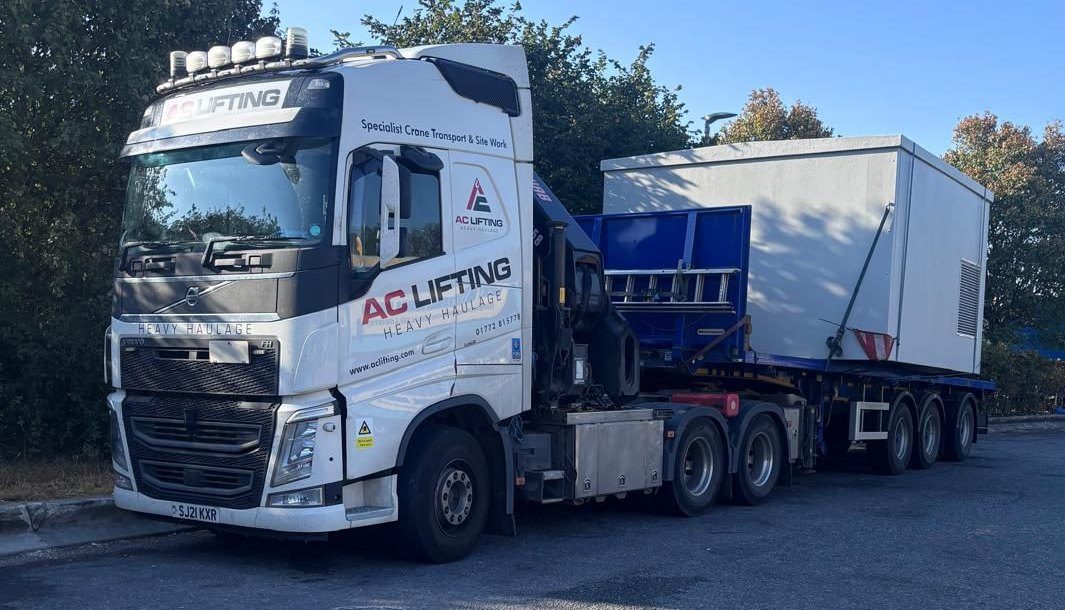 AC Lifting lorry and trailer delivering a modular cabin to site.