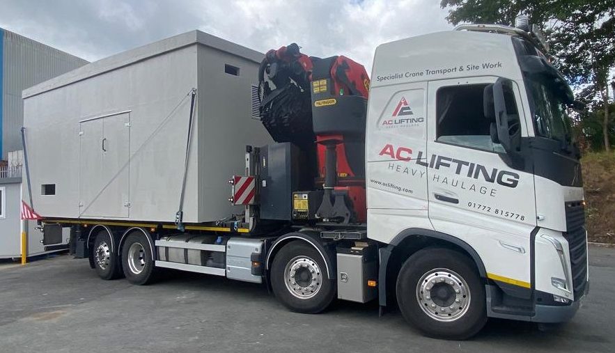 AC Lifting HIAB transporting a modular welfare cabin from the manufacturer.