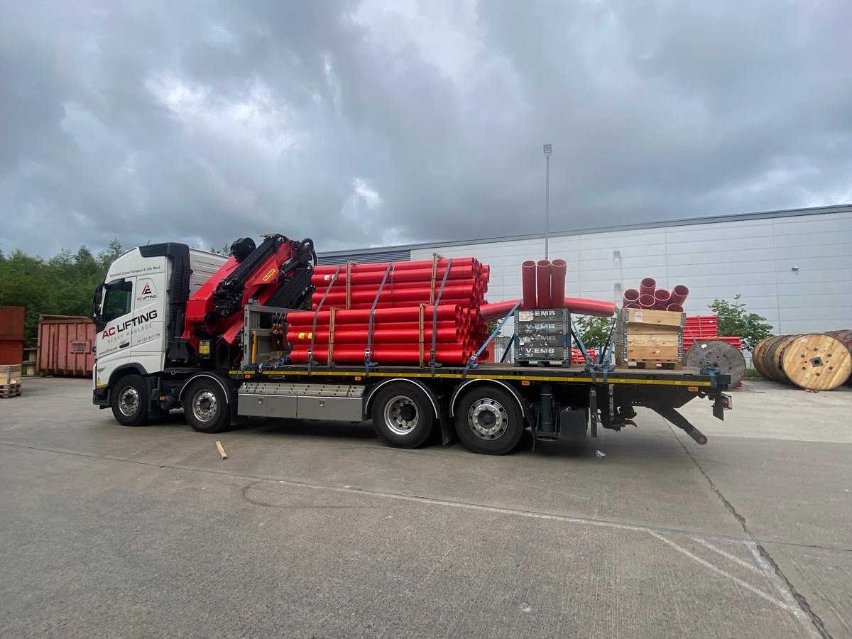 AC Lifting HIAB loaded with steel frames outside an industrial unit.